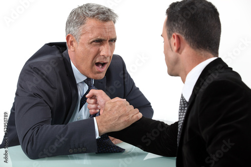 Photo: Businessmen fighting at desk Businessmen fighting at desk