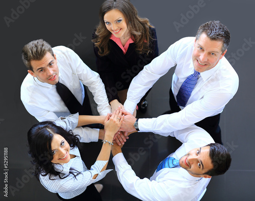 Photo: Top view of business people with their hands together Top view of business people with their hands together