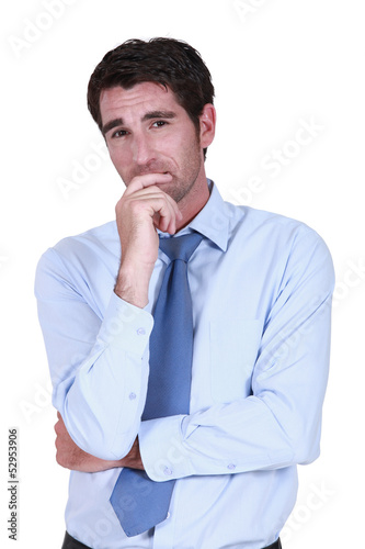 Photo: Pensive businessman rubbing chin Pensive businessman rubbing chin