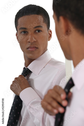 Photo: Young businessman adjusting tie before interview Young businessman adjusting tie before interview