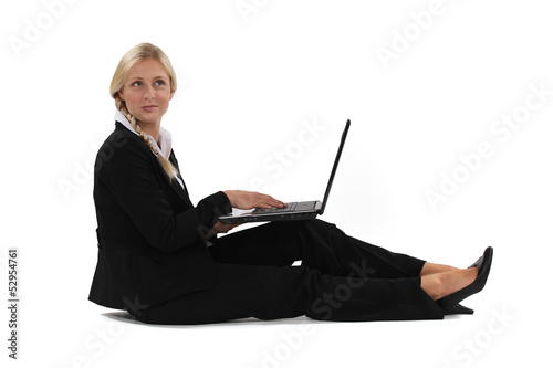 Photo: A businesswoman sitting on the floor with her laptop. A businesswoman sitting on the floor with her laptop.