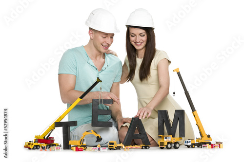 Photo: Forming a team: Cheerful man and woman building team-word. Forming a team: Cheerful man and woman building team-word.