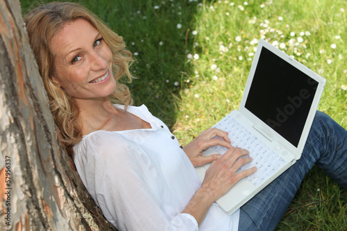 Photo: Woman on laptop outside Woman on laptop outside