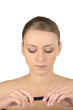 Woman with bare shoulders looking at a lipstick