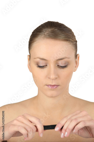 Photo: Woman with bare shoulders looking at a lipstick Woman with bare shoulders looking at a lipstick