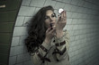 Woman looking in mirror and putting lipstick in underground