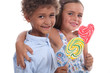 Foto: Two friendly kids eating colorful lollipops Two friendly kids eating colorful lollipops