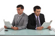Businessmen reading newspapers