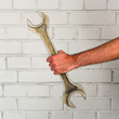 Man's hand holding a big spanner