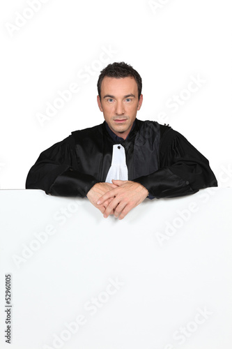 Photo: Man in graduation robe holding blank board Man in graduation robe holding blank board