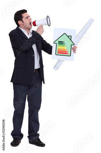 Photo: Businessman with a loudspeaker and energy rating card Businessman with a loudspeaker and energy rating card