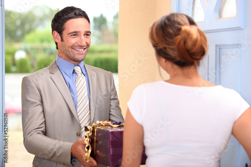 Photo: Man at the door with a present. Man at the door with a present.