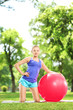 Young female athlete exercising with a ball in park