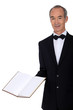 Middle-aged waiter holding menu