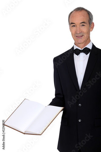 Photo: Middle-aged waiter holding menu Middle-aged waiter holding menu