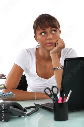 Photo: cute female student with computer looking pensive cute female student with computer looking pensive
