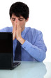 young businessman with laptop looking tired