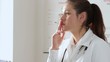 Young female doctor smoking in her workplace