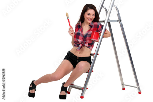 Photo: Sexy woman sat on ladder holding paint pot Sexy woman sat on ladder holding paint pot