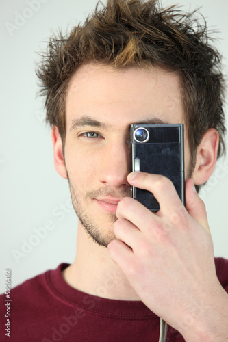 Photo: Man covering his eye with a camera Man covering his eye with a camera