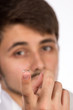Closeup view of a man's brown eye while inserting a corrective c