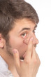 Closeup view of a man's brown eye while inserting a corrective c