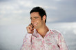Photo: Smiling man on the phone by the coast Smiling man on the phone by the coast