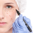 Beautician draw correction lines on woman face