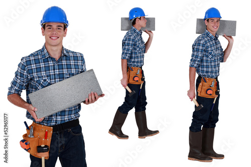 Photo: Worker carrying breeze block Worker carrying breeze block
