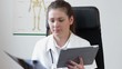 Female doctor with tablet computer looking at xray picture