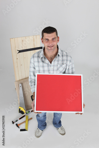 Photo: Carpenter holding up picture frame Carpenter holding up picture frame