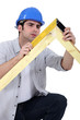 carpenter measuring a wooden frame
