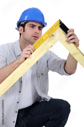 Photo: carpenter measuring a wooden frame carpenter measuring a wooden frame