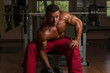 shirtless body builder doing heavy weight exercise for biceps
