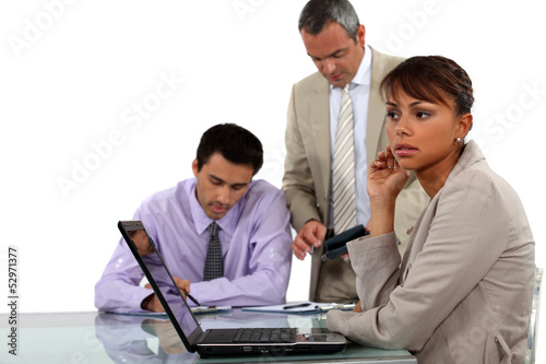 Photo: young businesswoman with laptop and male colleagues young businesswoman with laptop and male colleagues