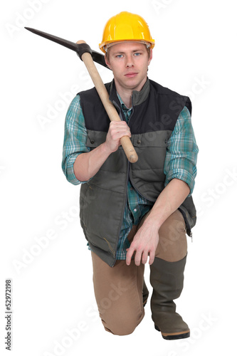 Photo: Man with pick-ax knelt on one knee Man with pick-ax knelt on one knee