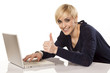 Photo: smiling blonde working on a laptop and showing thumbs up smiling blonde working on a laptop and showing thumbs up