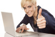 Photo: smiling blonde working on a laptop and showing thumbs up smiling blonde working on a laptop and showing thumbs up