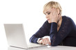 Photo: cute blonde bored on a laptop and looking at her watch cute blonde bored on a laptop and looking at her watch