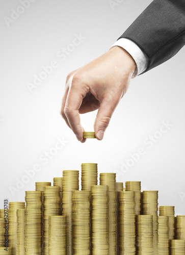 Photo: Hand put gold coins Hand put gold coins
