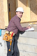 Photo: Foreman overseeing construction of wooden house Foreman overseeing construction of wooden house