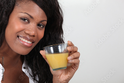 Photo: young woman drinking orange juice young woman drinking orange juice