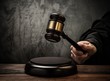 Foto: Judge's hold hammer on wooden table Judge's hold hammer on wooden table