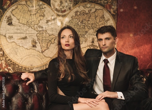 Photo: Beautiful woman and handsome young man sitting on a sofa Beautiful woman and handsome young man sitting on a sofa