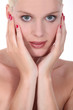 Portrait of attractive blond with hands to face