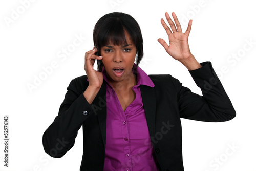 Photo: A black businesswoman angry over the phone. A black businesswoman angry over the phone.