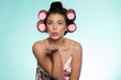 Sexy woman in curlers blowing a kiss