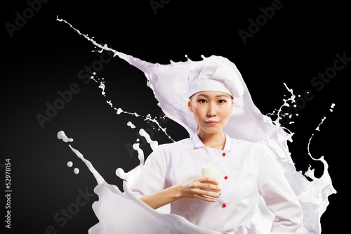 Photo: Asian female cook against milk splashes Asian female cook against milk splashes