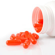 Orange pills an pill bottle on white background