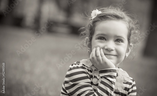 Photo: Black and white portrait of cute little girl in a park Black and white portrait of cute little girl in a park